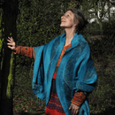 Elita Carstens in der Natur, Hand an einem Baum, nach oben schauend