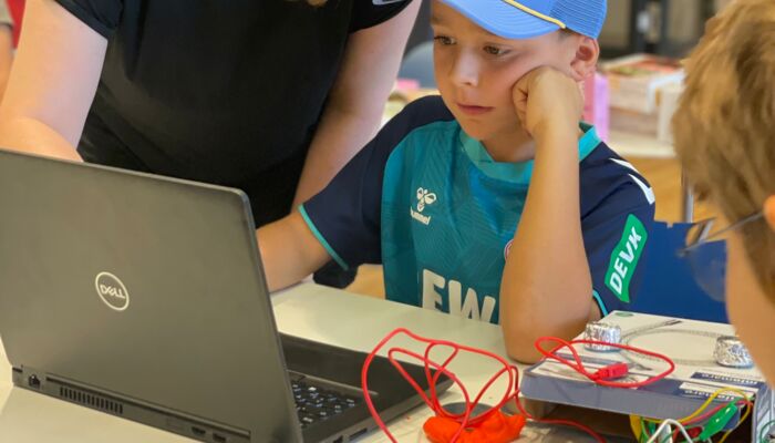 Junge sitzt vor einem Laptop und Makey Makey