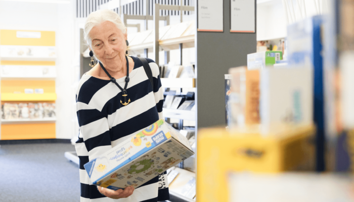 ältere Dame stöbert in der Bücherhalle