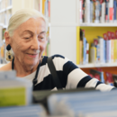 ältere Dame stöbert in der Bücherhalle