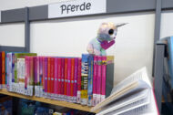 Ein Stofftier "liest" ein Pferdebuch
