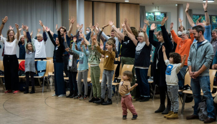 Menschen verschiedenen Alters singen, tanzen und lachen gemeinsam
