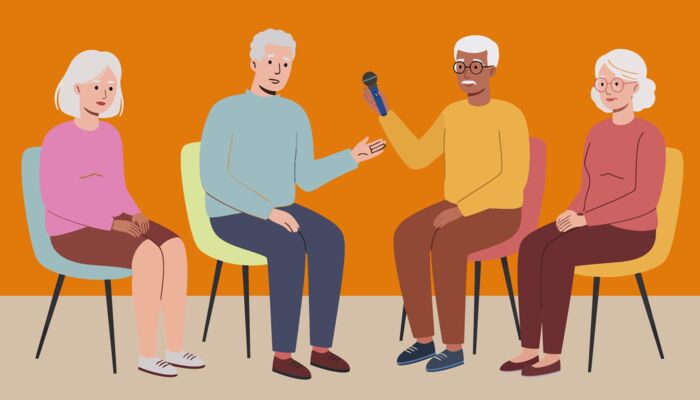 vier ältere Damen und Herren sitzen in einem Stuhlkreis unterhalten sich