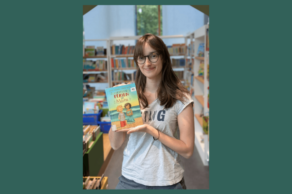 Die Person hält das Buch "Zuckerkringel-Ferien mit Marie" in den Händen.