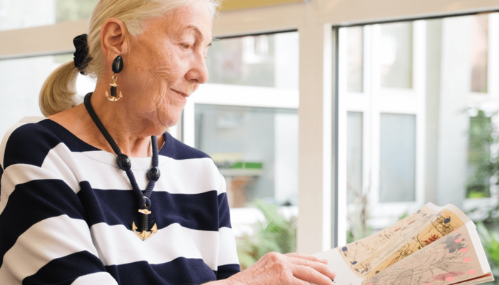 ältere Dame liest Zeitschrift in der Bücherhalle