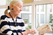 ältere Dame liest Zeitschrift in der Bücherhalle