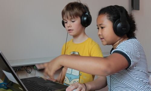 Kinder mit Kopfhörer und Laptop