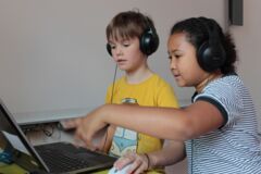 Kinder mit Kopfhörer und Laptop