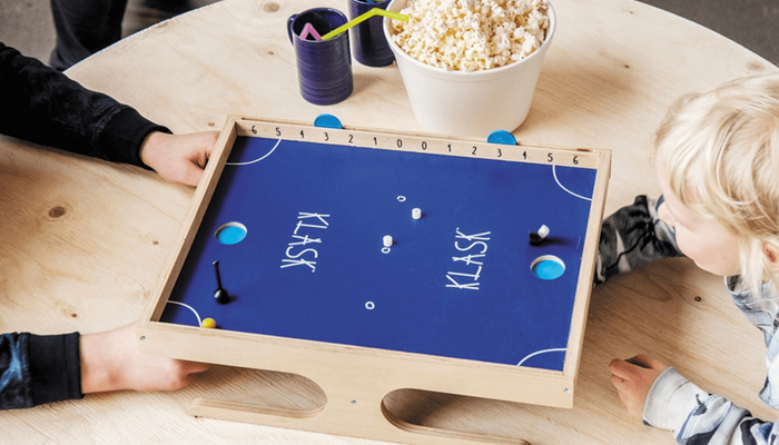 Zwei Kinder spielen das Geschicklichkeitsspiel "KLASK".