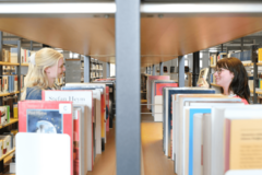 Zwei Personen stöbern Bücher in der Zentralbibliothek