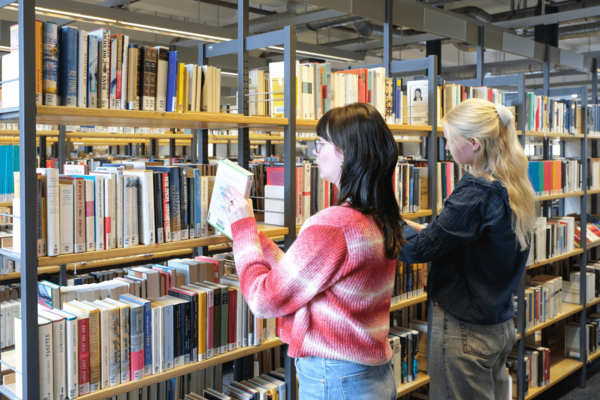 Zwei Personen stöbern Bücher in der Zentralbibliothek