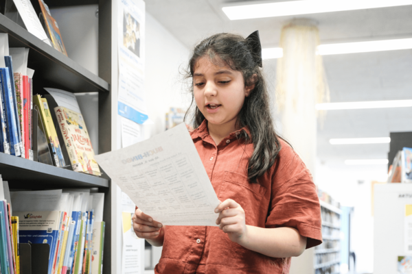 Mädchen hält Buchbingo-Bogen in der Hand