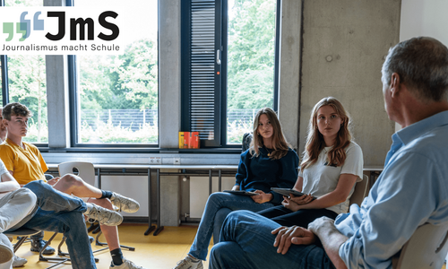 Eine Gruppe sitz im Stuhlkreis und unterhält sich.