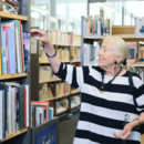 ältere Dame stöbert in der Bücherhalle