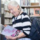 ältere Dame stöbert in der Bücherhalle