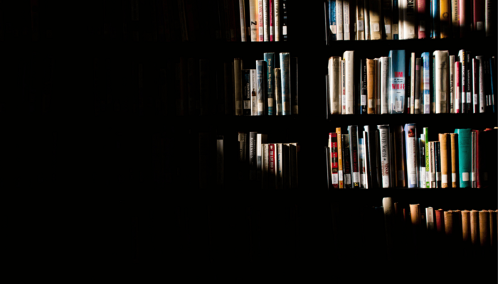 Ein Bücherregal, von dem die Hälfte im Schatten liegt