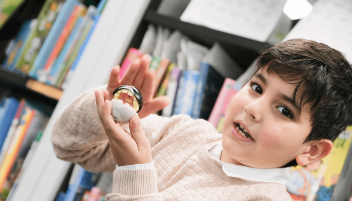 Junge hält Figur in Kamera