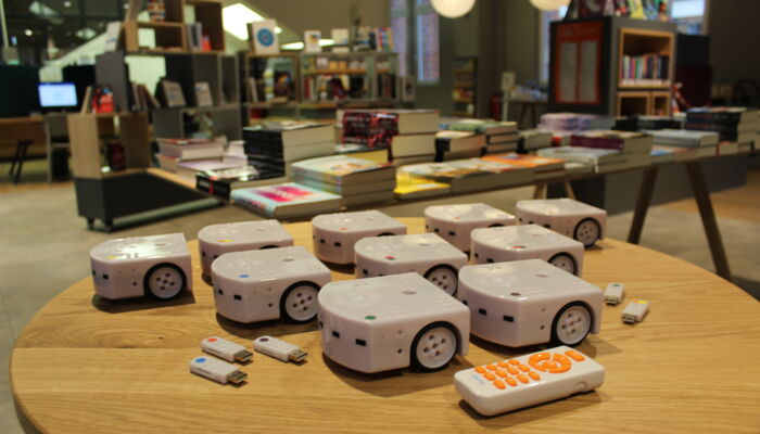 Thymio Roboter mit USB Sticks und Fernbedienung auf einem Tisch