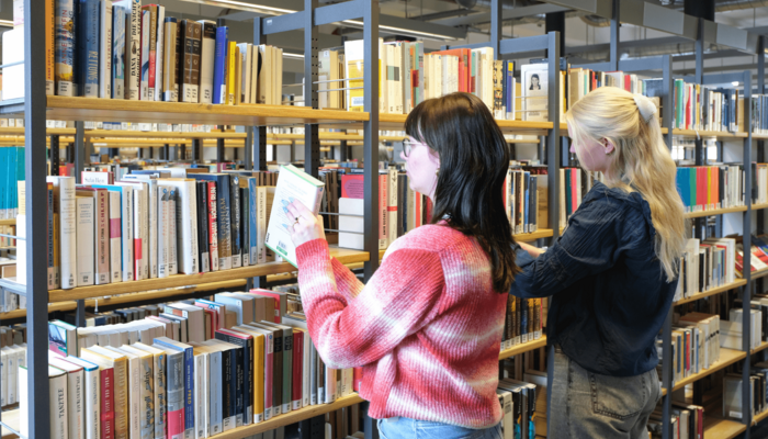 Zwei Personen stöbern Bücher in der Zentralbibliothek