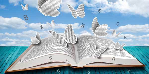 Aufgeschlagenes Buch, darüber ein blauer Himmel mit weißen Wolken und Schmetterlingen