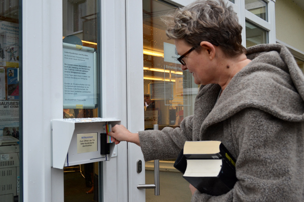 Kundin öffnet Bücherhalleneingang mit ihrer Kundenkarte